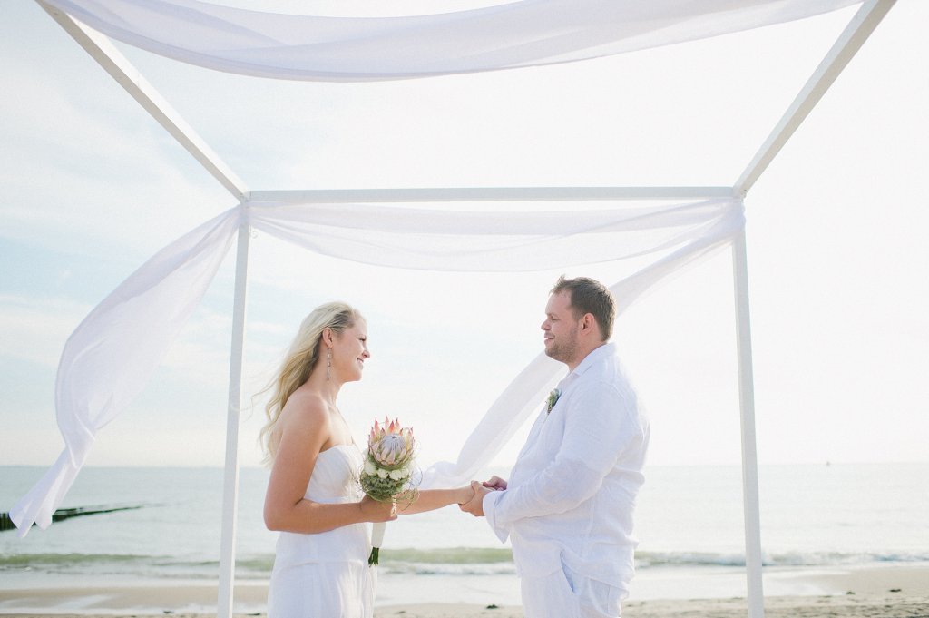 Photo Braut und Bräutigam unter einem Baldachin am Strand